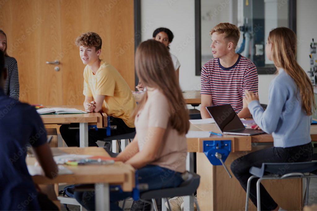 Regroupement d'adolescents dans une salle de classe pour parler du harcèlement scolaire