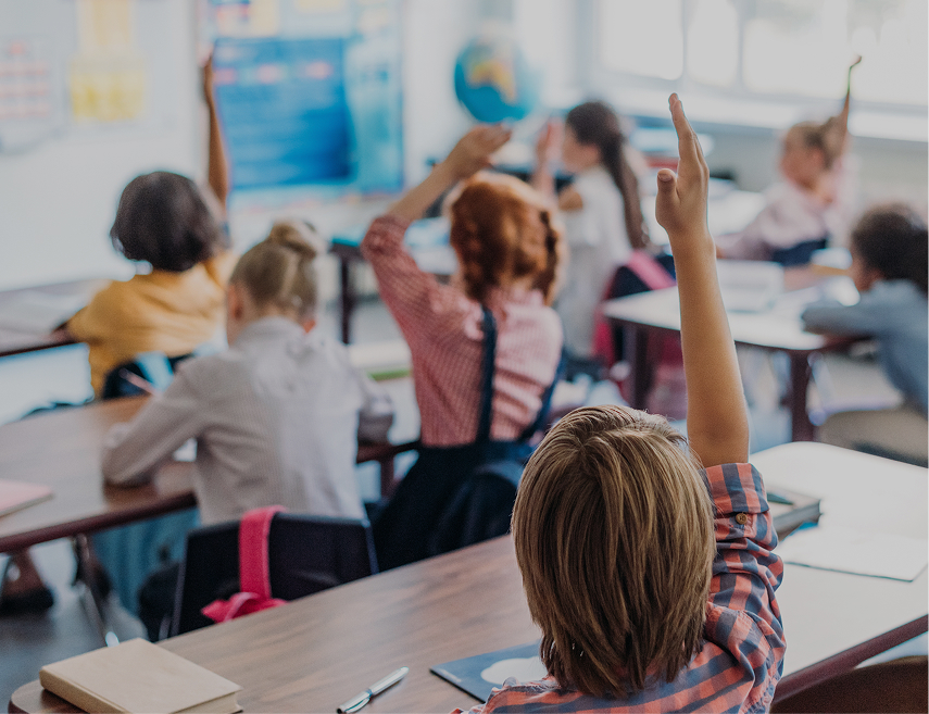 Groupe d'étudiants en classe levant le doigt pour répondre à une question